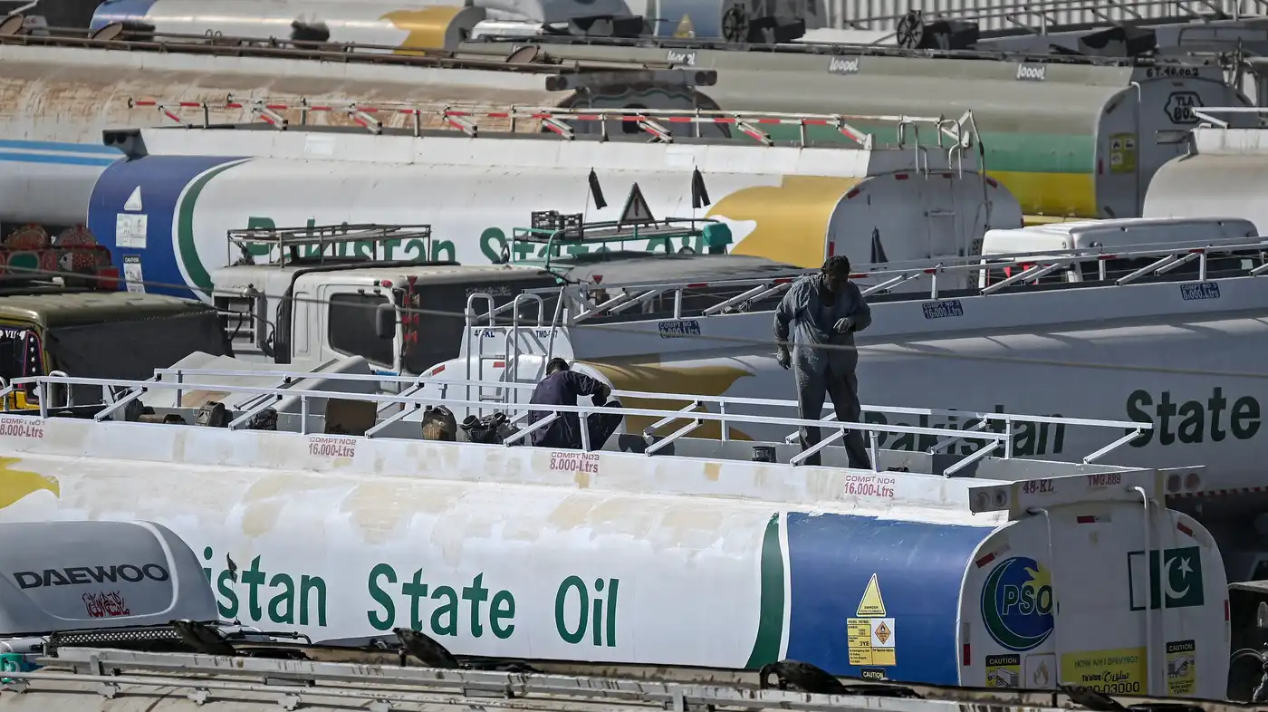 Workers stand on top of an oil tanker parked near an oil storage terminal in Karachi, Pakistan. The country is facing unprecedentedly high fuel prices.Riswan Tabassum/AFP via Getty Images